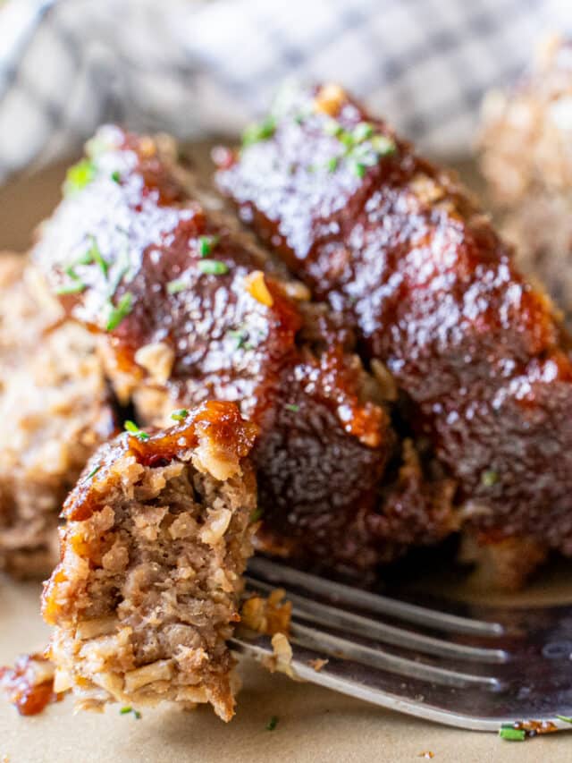 A fork lies on a tray with a sliced Impossible Meatloaf in the background.
