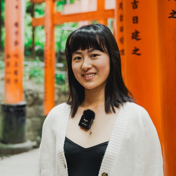 Girl standing in front of Fushimi Inari shrine.